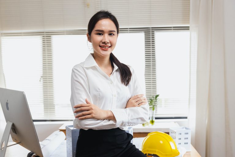 portrait of Engineer woman with model for architecture work in office